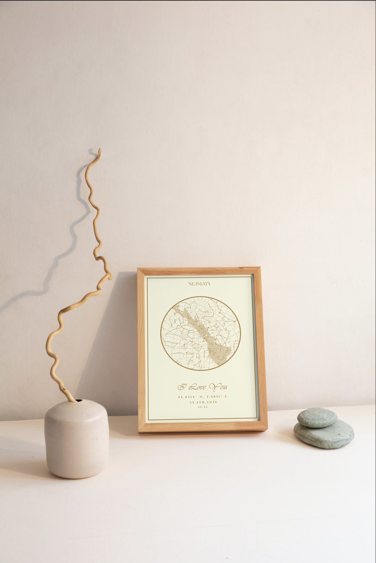 Framed star map on a table with a vase and stones
